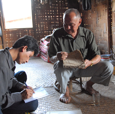 A National Library of Laos researcher collecting information about a Tai Dam manuscript. Luang Namtha province, 2007.