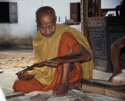 Reading a palm-leaf manuscript, Luang Prabang